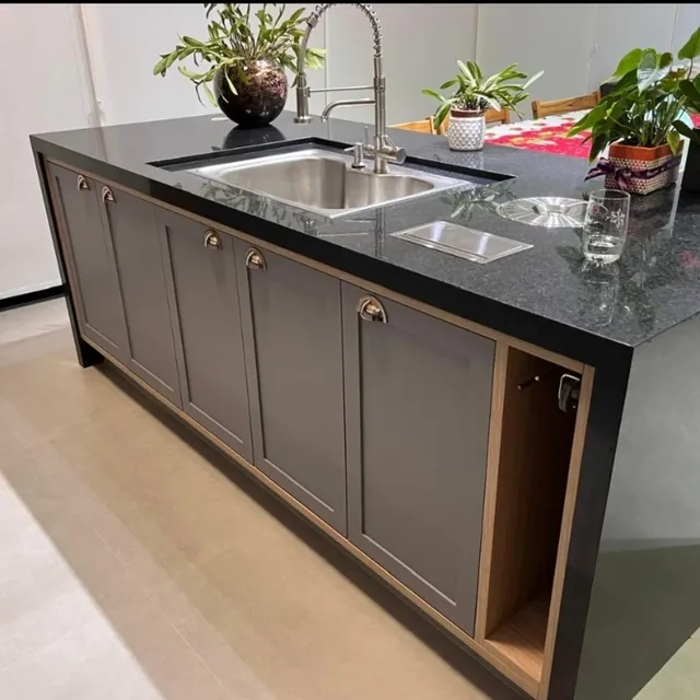 Ilha de cozinha com portas almofadadas cinza e tampo de granito preto