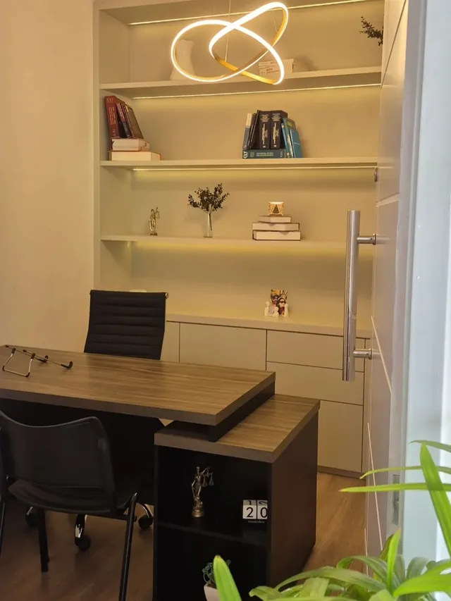 Escritório com mesa em L e estante iluminada